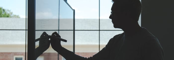 man writing on a board